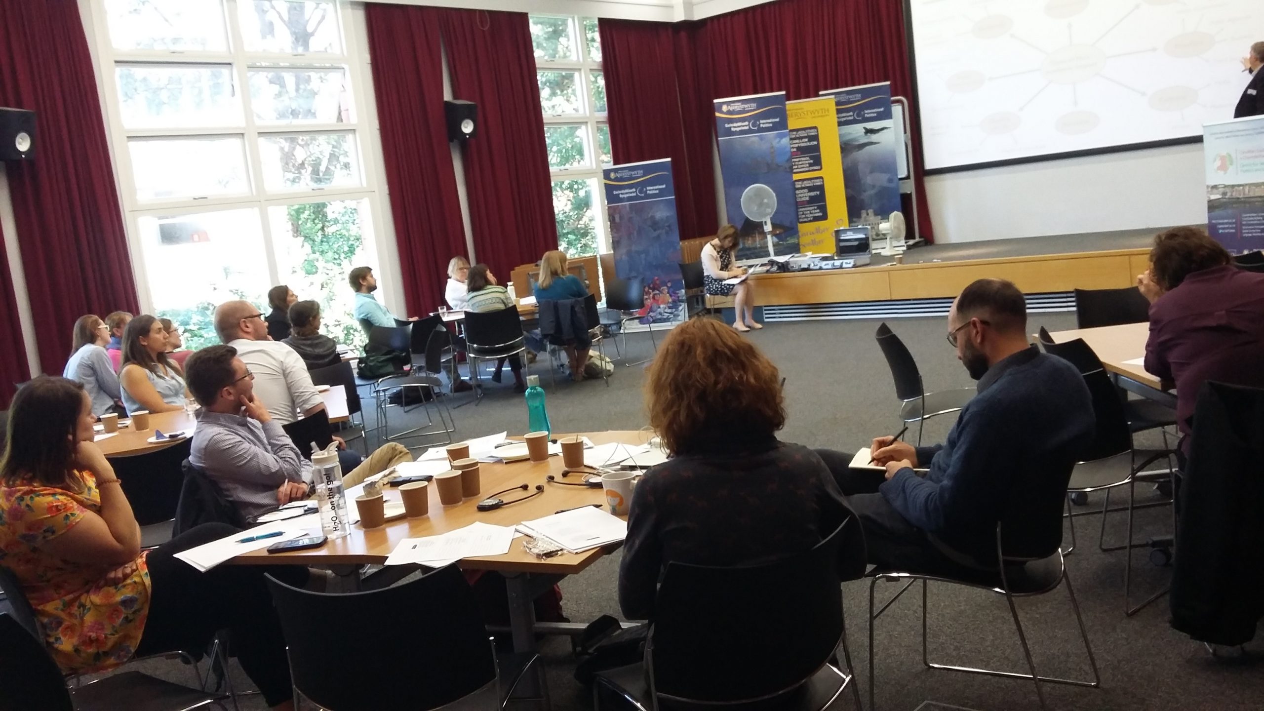 Attendees sitting at tables at the PhD 'Resesarching Wales' event